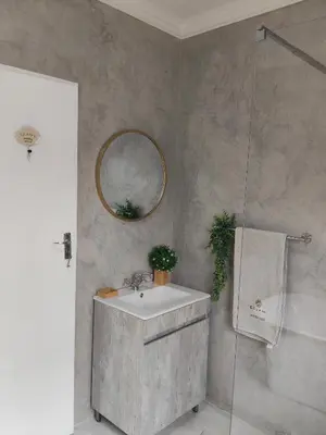 a bathroom with a sink and a mirror and a shower at Edjami River View in Marloth Park