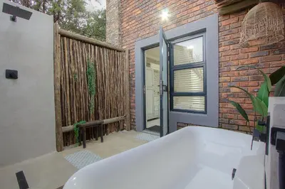 a bath tub in front of a brick building at Edjami River View in Marloth Park