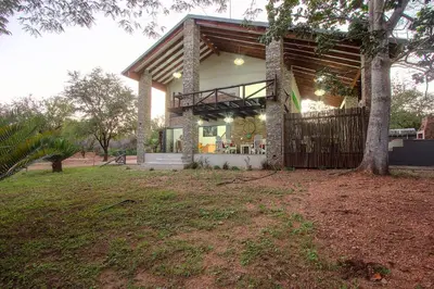 a house with a tree in front of it at Edjami River View in Marloth Park