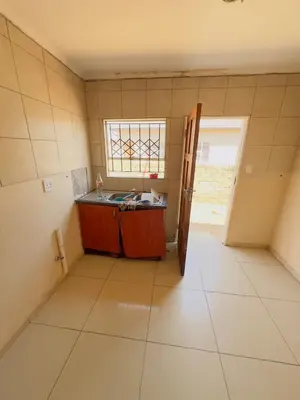 an empty kitchen with a sink and a window at Private Suite in Polokwane