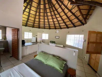 a room with a bed and a kitchen with a ceiling at Kettie&Klip Self Catering Accommodation in Marloth Park