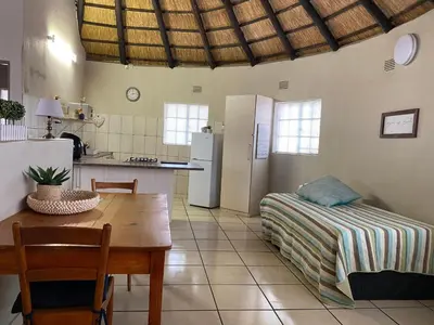 a kitchen and dining room with a table and a bed at Kettie&Klip Self Catering Accommodation in Marloth Park