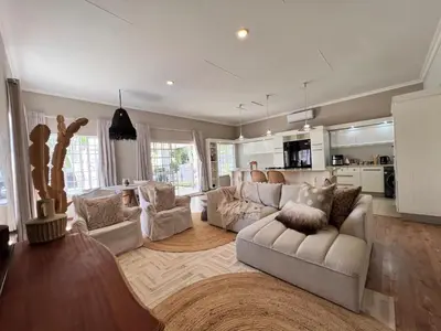 a living room with two white couches and a kitchen at Whispering Thorns Off-Site Apartment in White River