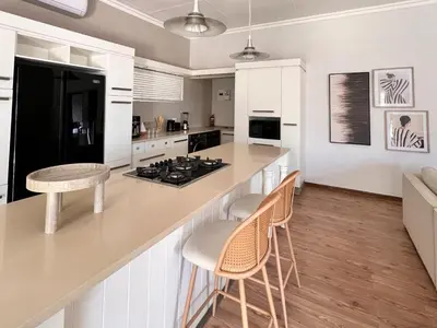 a kitchen with white cabinets and a counter with stools at Whispering Thorns Off-Site Apartment in White River
