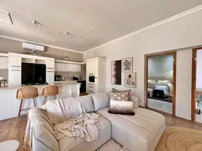 a living room with a couch and a kitchen at Whispering Thorns Off-Site Apartment in White River