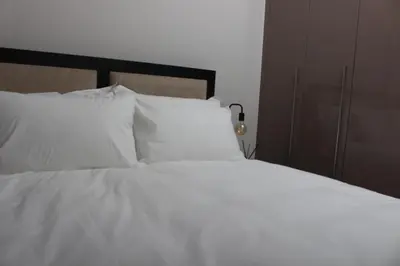 a white bed with white sheets and pillows at Blue Lake Estate Home in Midrand