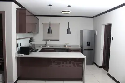 a kitchen with a counter and a refrigerator at Blue Lake Estate Home in Midrand