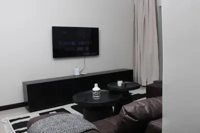 a living room with two tables and a television at Blue Lake Estate Home in Midrand