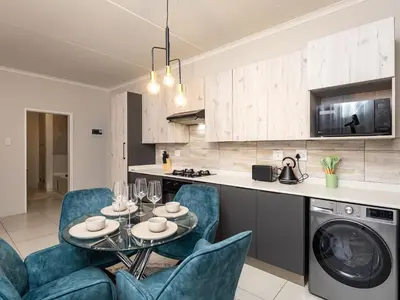 a kitchen and living room with a table and chairs at Reece Luxury Midrand Suite in Midrand