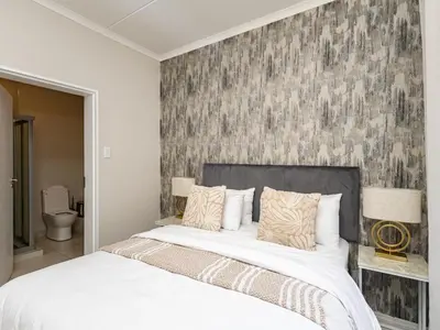 a bedroom with a large bed and a wall mural at Reece Luxury Midrand Suite in Midrand