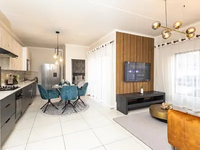 a kitchen and living room with a table and chairs at Reece Luxury Midrand Suite in Midrand