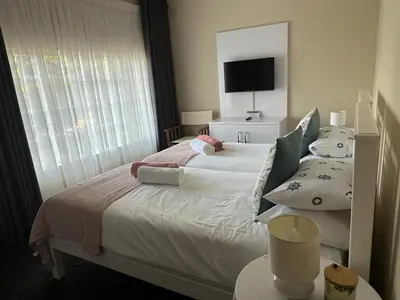 a bedroom with a bed with a mirror and a window at Tranquil view lodge in Haenertsburg