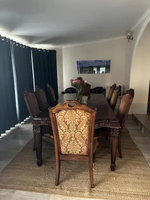 a dining room with a wooden table and chairs at Tranquil view lodge in Haenertsburg