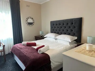 a bedroom with a large bed with a large headboard at Tranquil view lodge in Haenertsburg