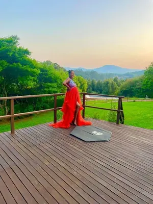 a man in a red dress sitting on a boardwalk at Tranquil view lodge in Haenertsburg
