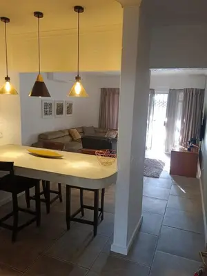 a living room with a table and a couch at Zamabhele Properties in Nelspruit
