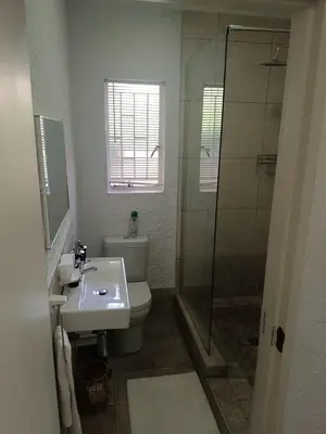 a bathroom with a toilet and a shower and a sink at Zamabhele Properties in Nelspruit