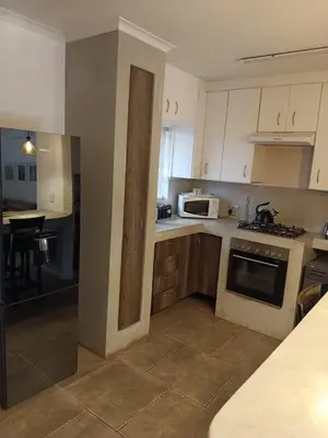 a kitchen with white cabinets and a stove top oven at Zamabhele Properties in Nelspruit
