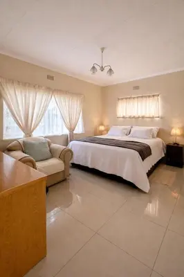 a large bedroom with a large bed and a couch at Meadway on the parks in Benoni