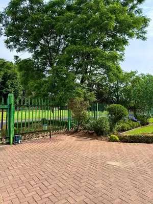 a park with a fence and a tree and a bench at Meadway on the parks in Benoni