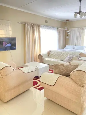 a living room with two couches and a bed at Meadway on the parks in Benoni