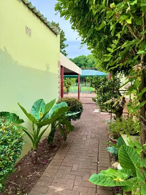 a brick walkway in a garden with plants at Meadway on the parks in Benoni