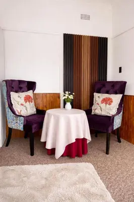 a room with two chairs and a table with a vase on it at Cosy retreat for 2 at MeadWay in Benoni