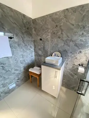 a bathroom with a sink and a chair in it at Cosy retreat for 2 at MeadWay in Benoni