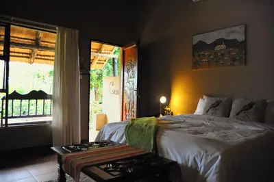 a bedroom with a bed and a large window at Palmwag Tzaneen in Tzaneen
