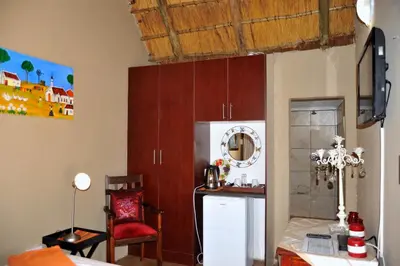 a kitchen with a white refrigerator and a red chair at Palmwag Tzaneen in Tzaneen