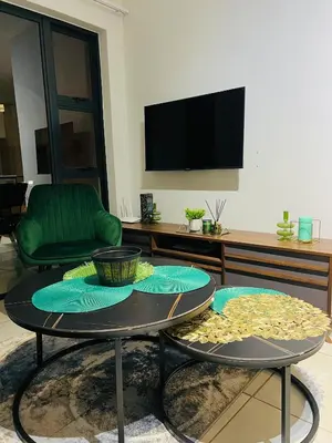 a living room with a table and a tv at Lagoon - The Blyde in Pretoria