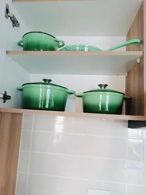 three green pots sitting on shelves in a kitchen at Lagoon - The Blyde in Pretoria