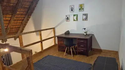 an attic room with a desk and a chair at Dika Dika Den in Phalaborwa