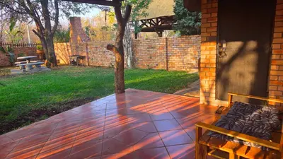 a patio with a bench and a brick wall at Dika Dika Den in Phalaborwa