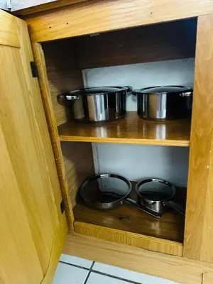 two pots and pans in a wooden cabinet at SerenityStay 37 on Zebra in Polokwane