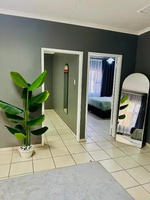 a room with a plant and a room with a bedroom at SerenityStay 37 on Zebra in Polokwane