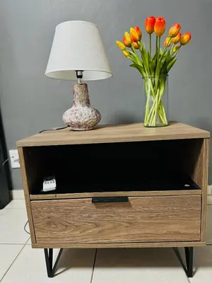 a table with a vase of flowers and a lamp at SerenityStay 37 on Zebra in Polokwane