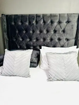 a bed with two pillows and a black headboard at SerenityStay 37 on Zebra in Polokwane