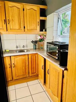 a kitchen with wooden cabinets and a sink at SerenityStay 37 on Zebra in Polokwane