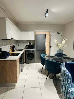 a kitchen with a table and a dining room at The Corinthians in Pretoria