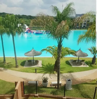 a view of a large pool with palm trees at The Corinthians in Pretoria