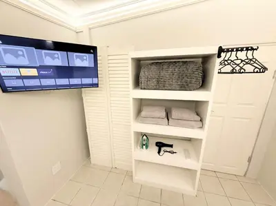 a room with a tv and a white door with towels at Blanche Guesthouse in Pretoria