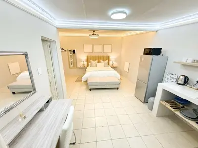 a large room with a bed and a refrigerator at Blanche Guesthouse in Pretoria