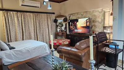 a living room with a couch and a television at Rose Vintage Cottage in Pretoria