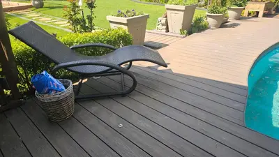 a black bench sitting on a deck with a basket at Rose Vintage Cottage in Pretoria