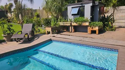a swimming pool in a yard with a house at Rose Vintage Cottage in Pretoria