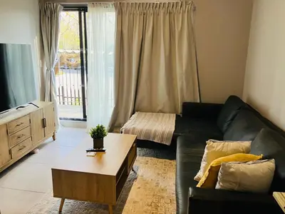 a living room with a couch and a coffee table at Circa 43 1 Bedroom Lynwood in Pretoria