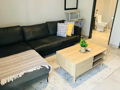 a black couch and a coffee table in a living room at Circa 43 1 Bedroom Lynwood in Pretoria