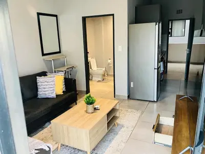 a living room with a couch and a coffee table at Circa 43 1 Bedroom Lynwood in Pretoria