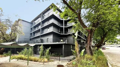 a black building with a tree in front of it at Circa 43 1 Bedroom Lynwood in Pretoria
